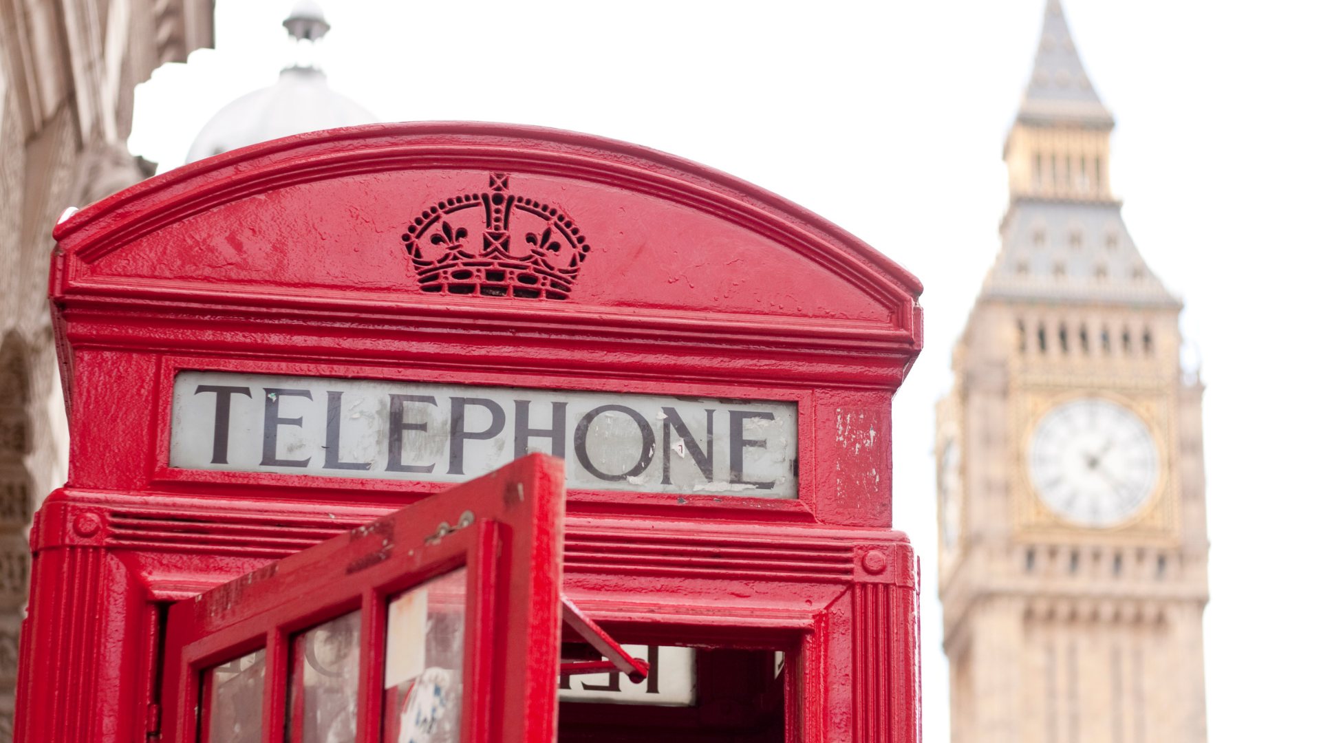Red telephone box with the Elizabeth Tower and Big Ben clock face behind