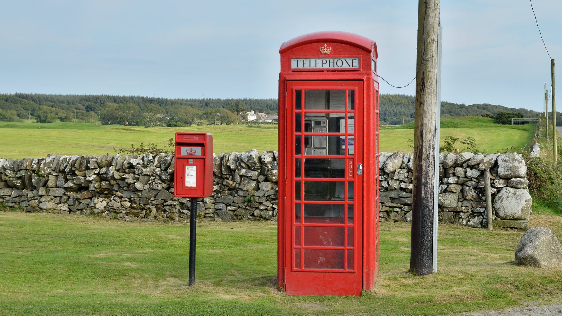 Paired for a century: kiosk and post box on the dry stone wall road.