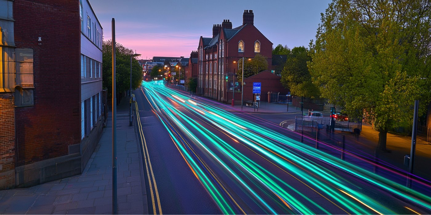 Long exposure light trails sweeping along a UK street at dusk